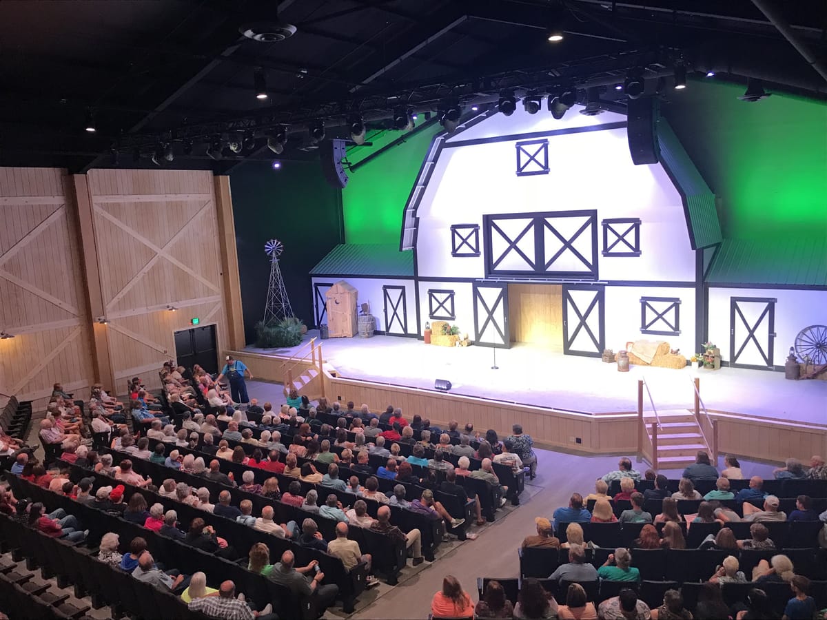 A full house in the 600-seat Amish Country Theater, with the white barn-front stage lit against a green wall