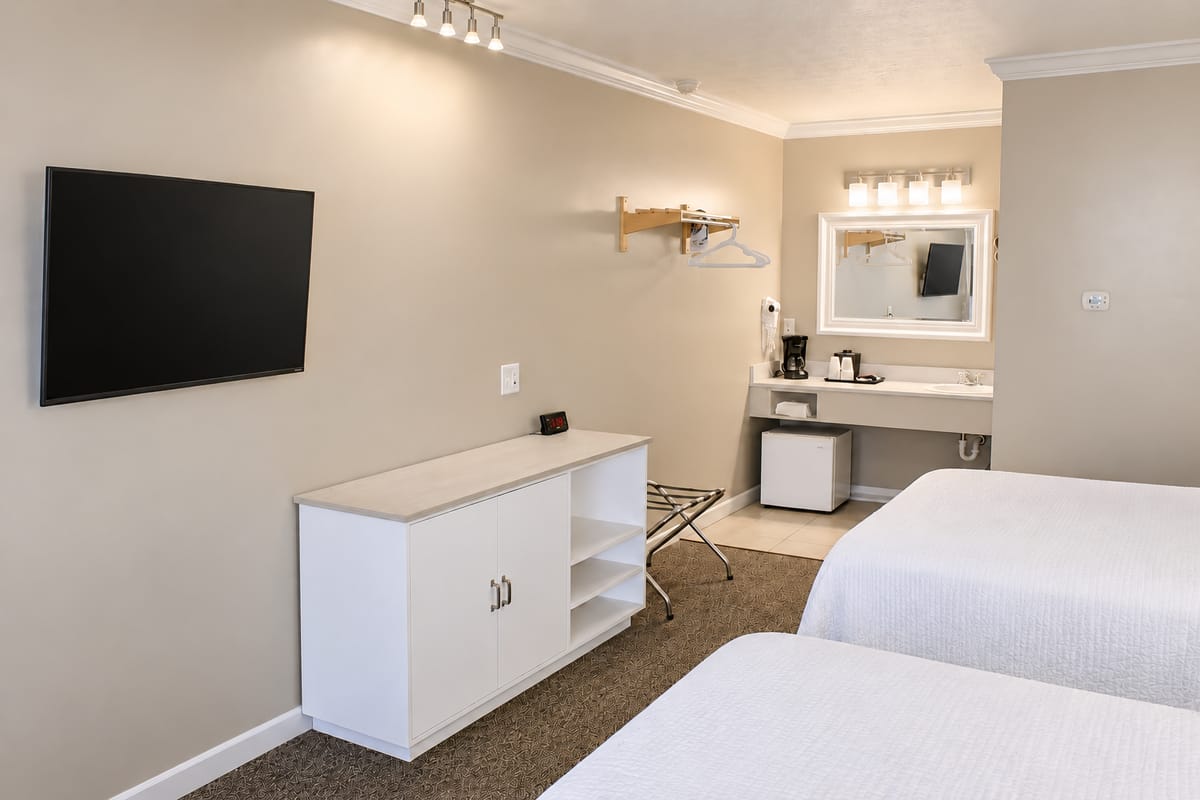 Flat-screen TV facing two double beds